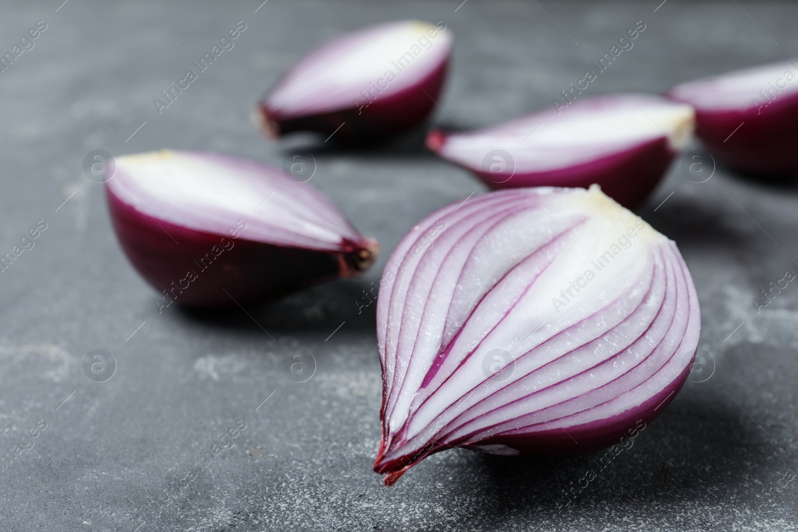 Photo of Cut ripe red onions on grey table