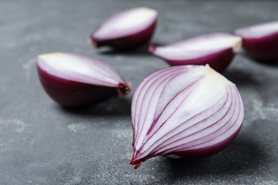 Photo of Cut ripe red onions on grey table