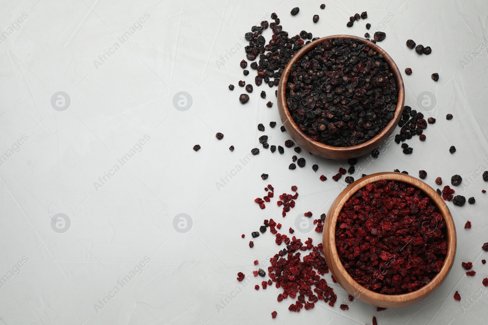 Photo of Dried red and black currant berries on light table, flat lay. Space for text