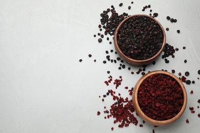 Photo of Dried red and black currant berries on light table, flat lay. Space for text