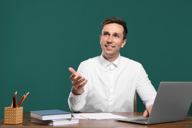 Photo of Portrait of male teacher working at table against color background