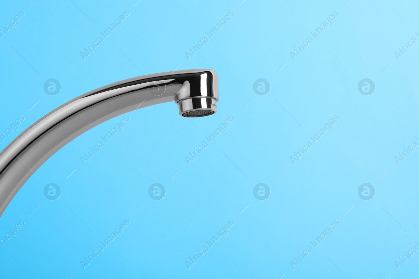 Photo of Modern water tap on light blue background, closeup. Space for text