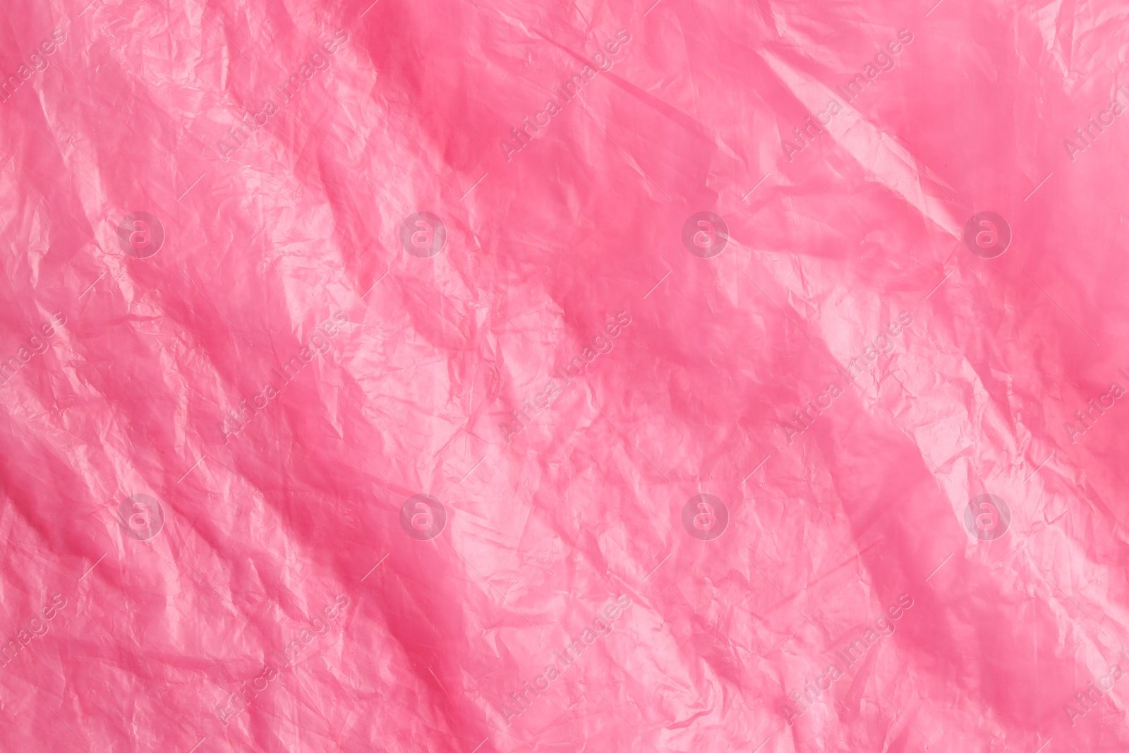 Photo of Crumpled pink plastic bag as background, top view