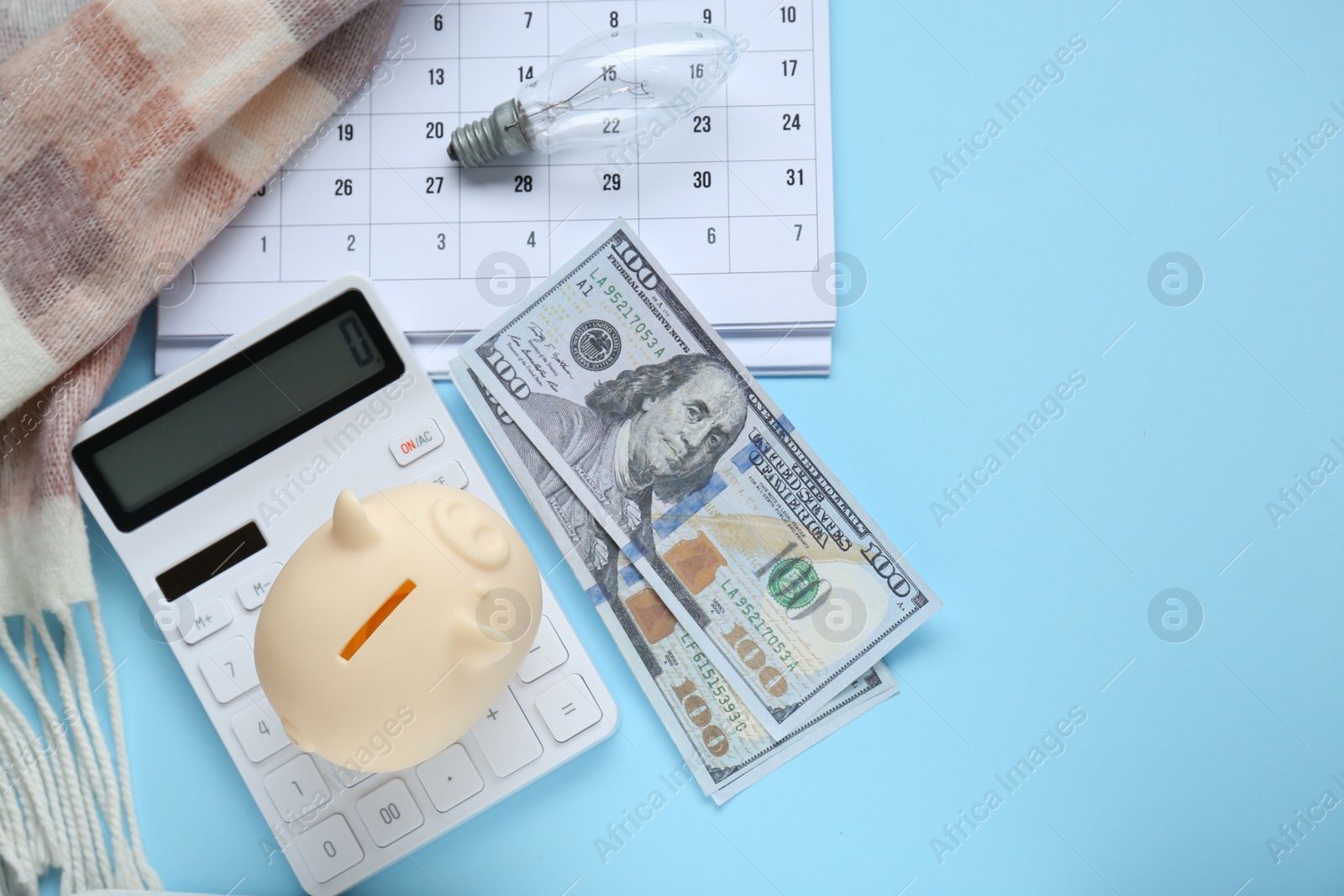 Photo of Flat lay composition with piggy bank and calculator on light blue background. Space for text