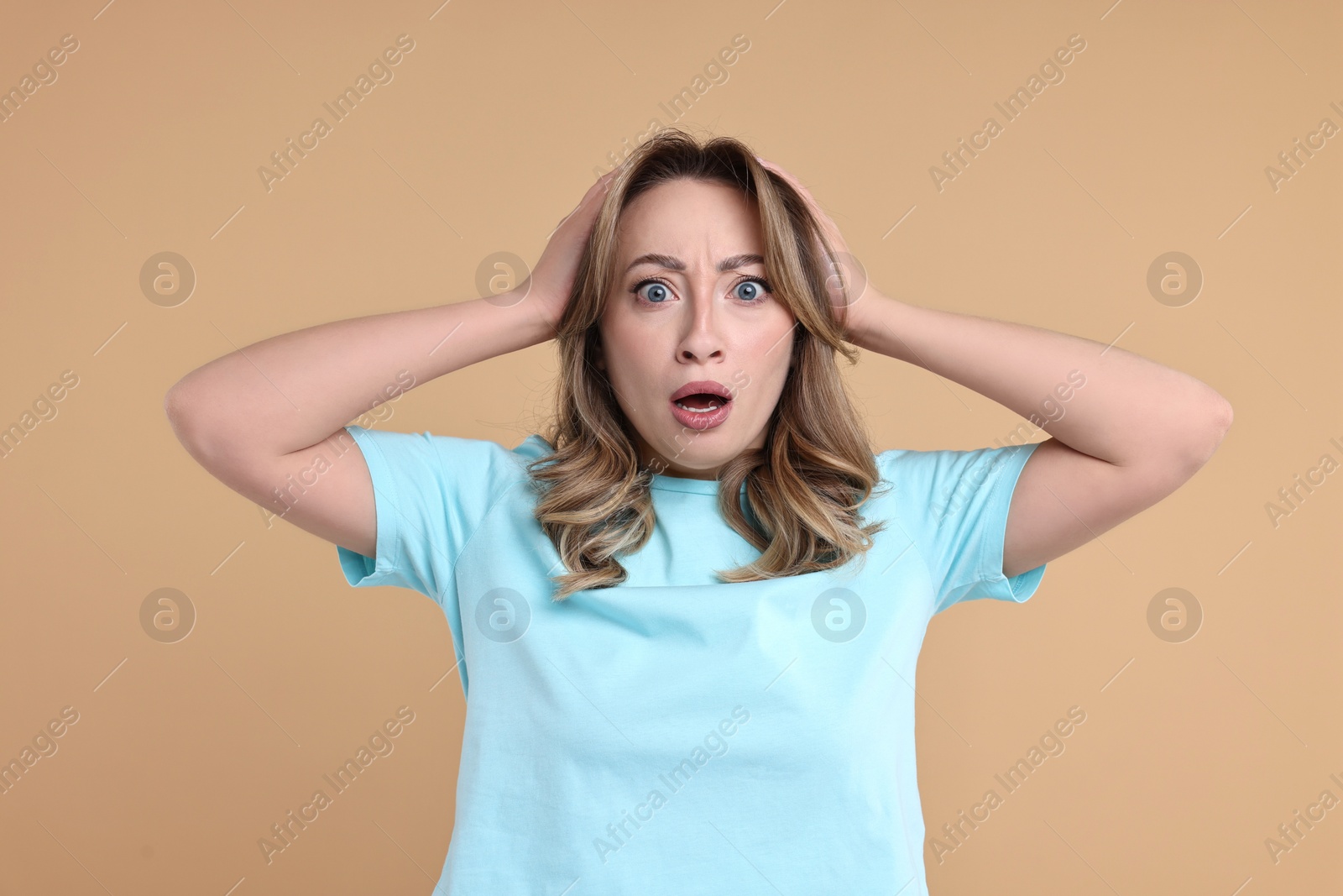 Photo of Portrait of surprised woman on beige background