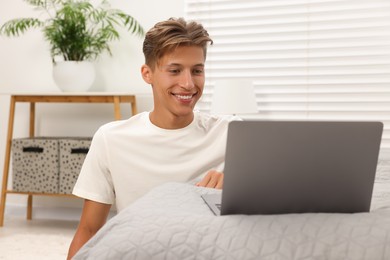 Happy young man having video chat via laptop indoors