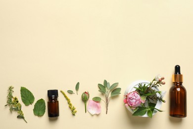 Bottles of essential oils, different herbs and rose flower on beige background, flat lay. Space for text