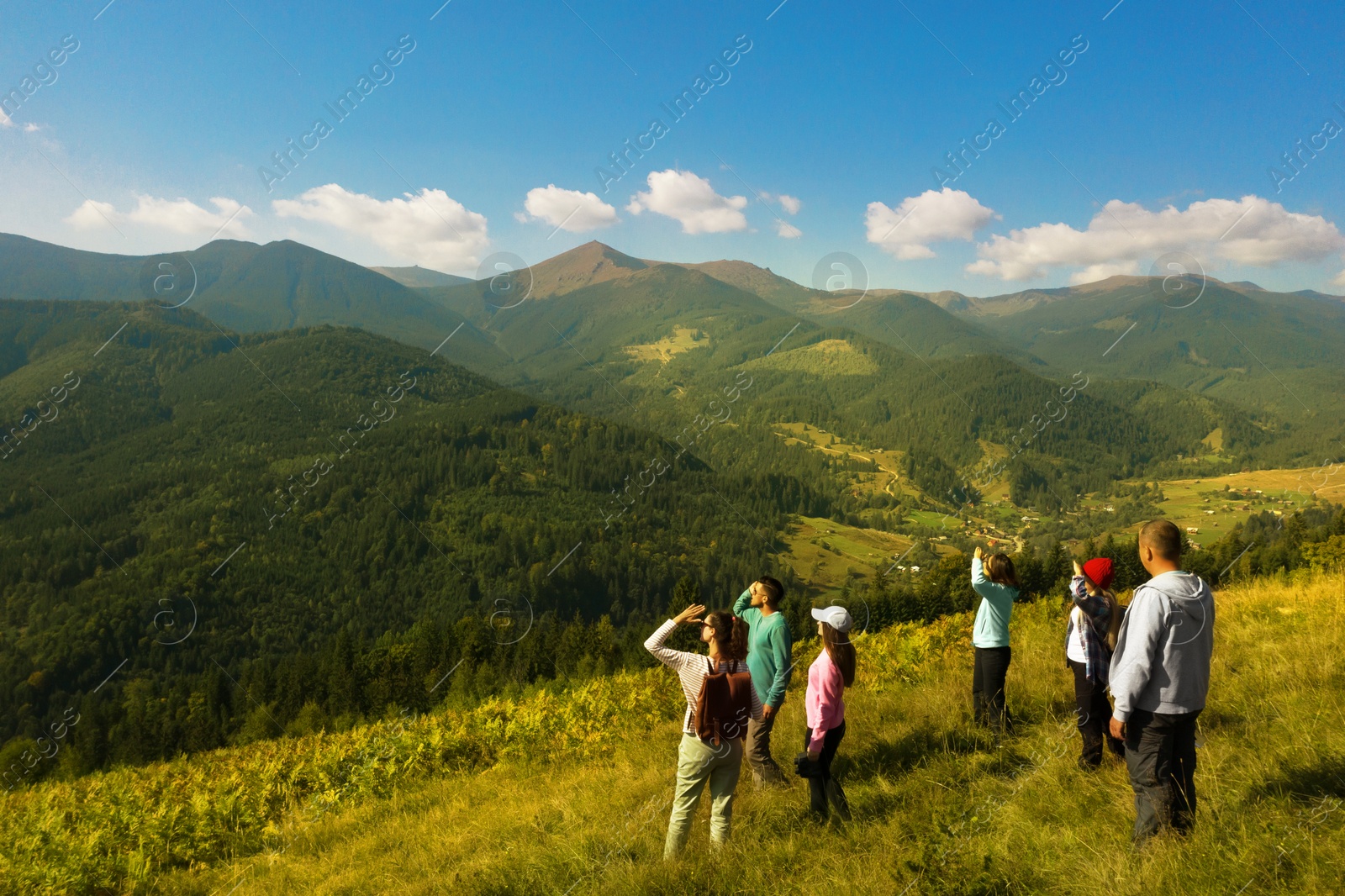 Image of Group of tourists on hill in mountains. Drone photography