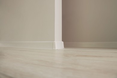 Photo of White walls and laminated floor in office room. Interior design