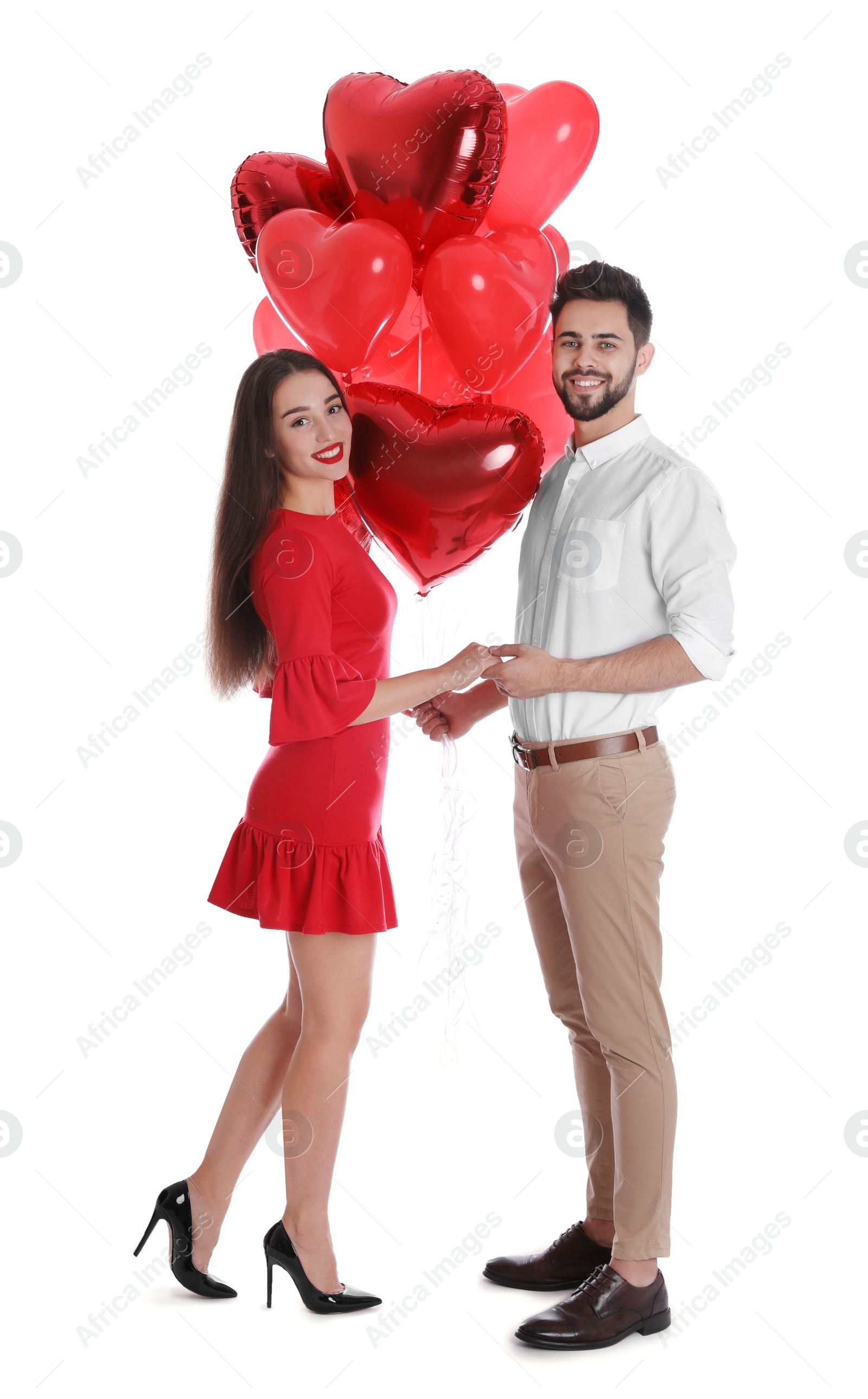 Photo of Happy young couple with heart shaped balloons isolated on white. Valentine's day celebration