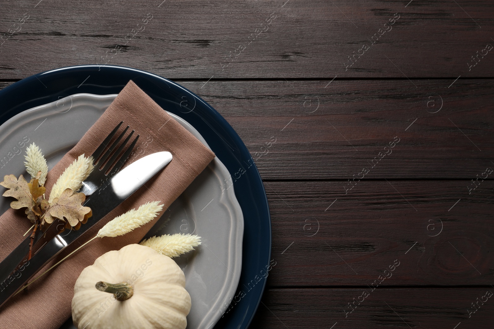 Photo of Autumn table setting on wooden background, top view. Space for text