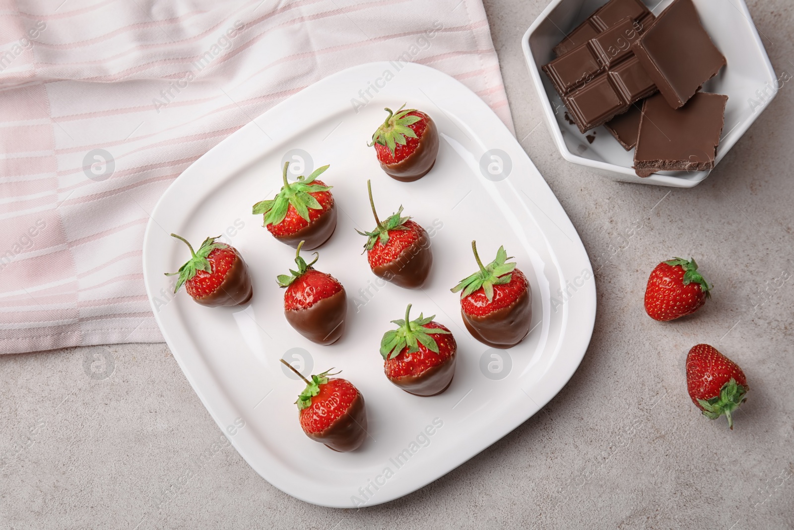 Photo of Flat lay composition with chocolate covered strawberries on grey background