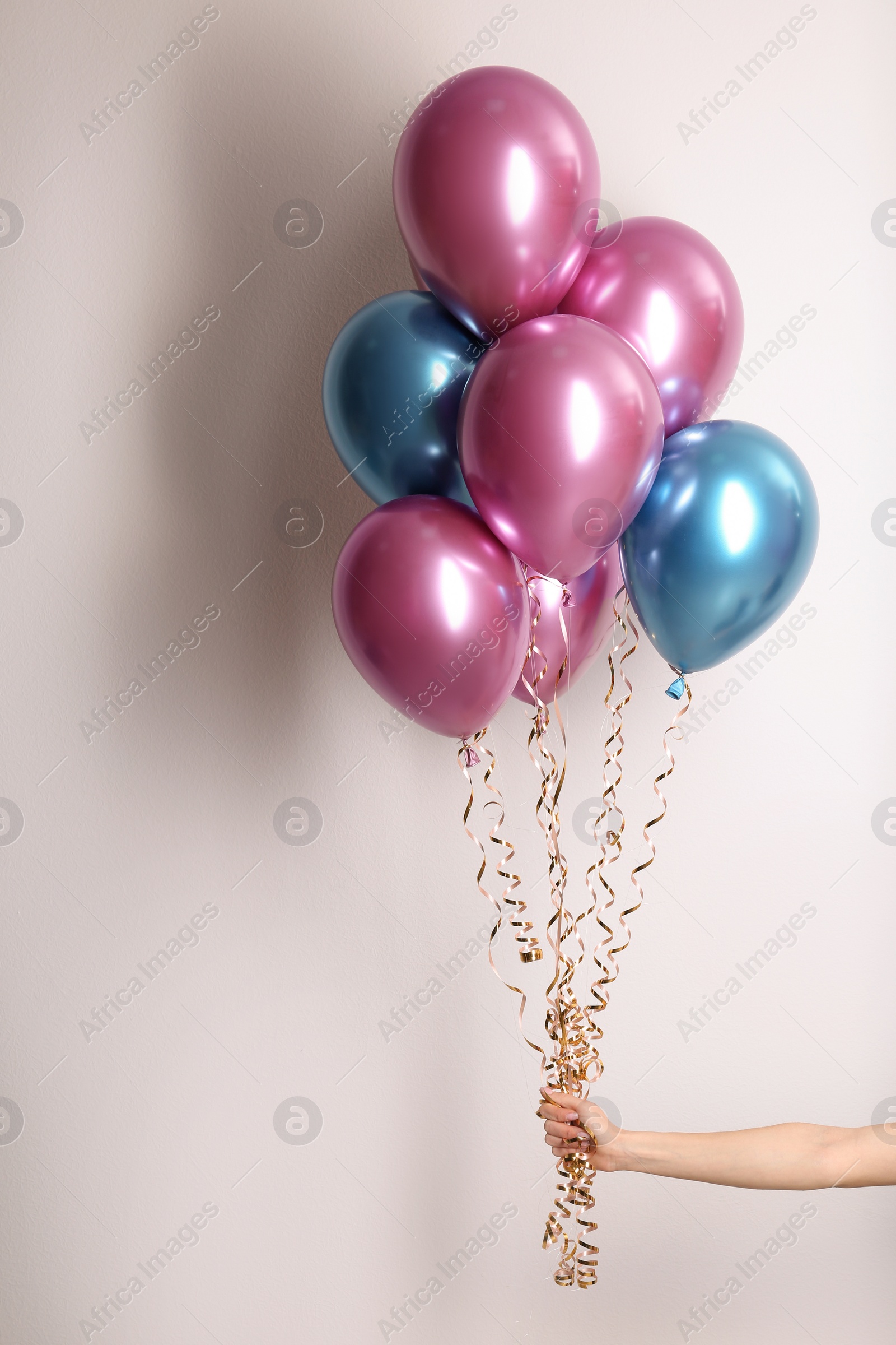 Photo of Woman holding bunch of balloons on white background, closeup