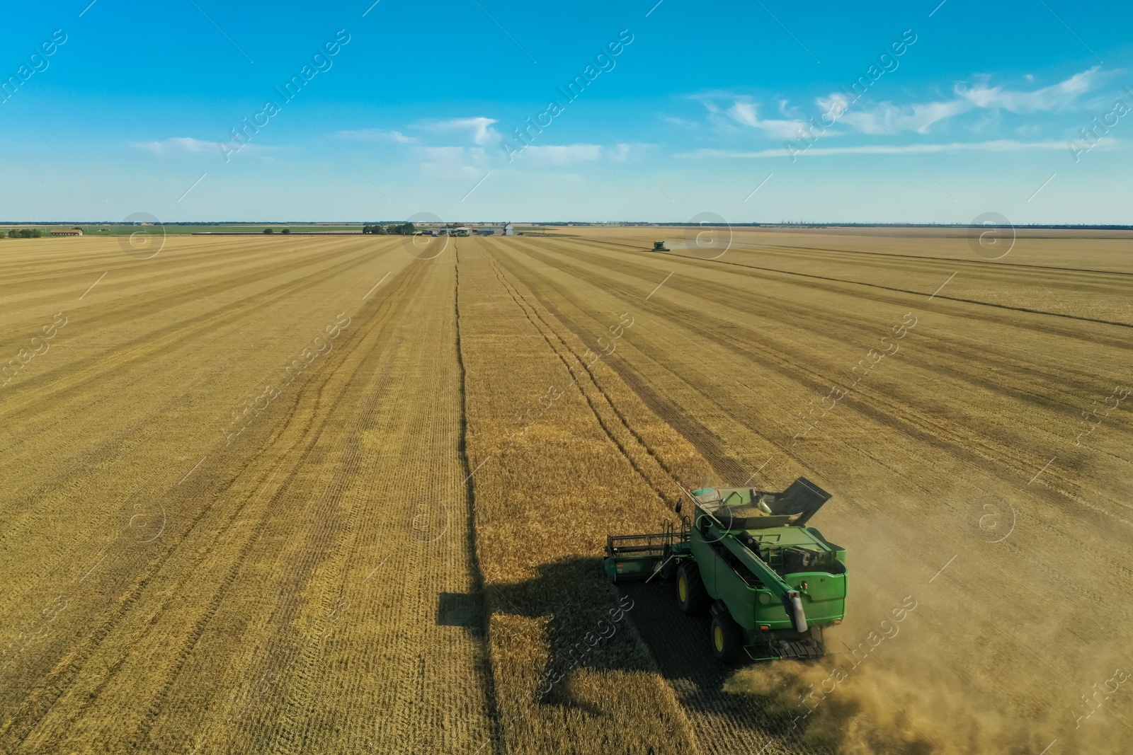 Photo of Modern combine harvester working in field on sunny day. Agriculture industry