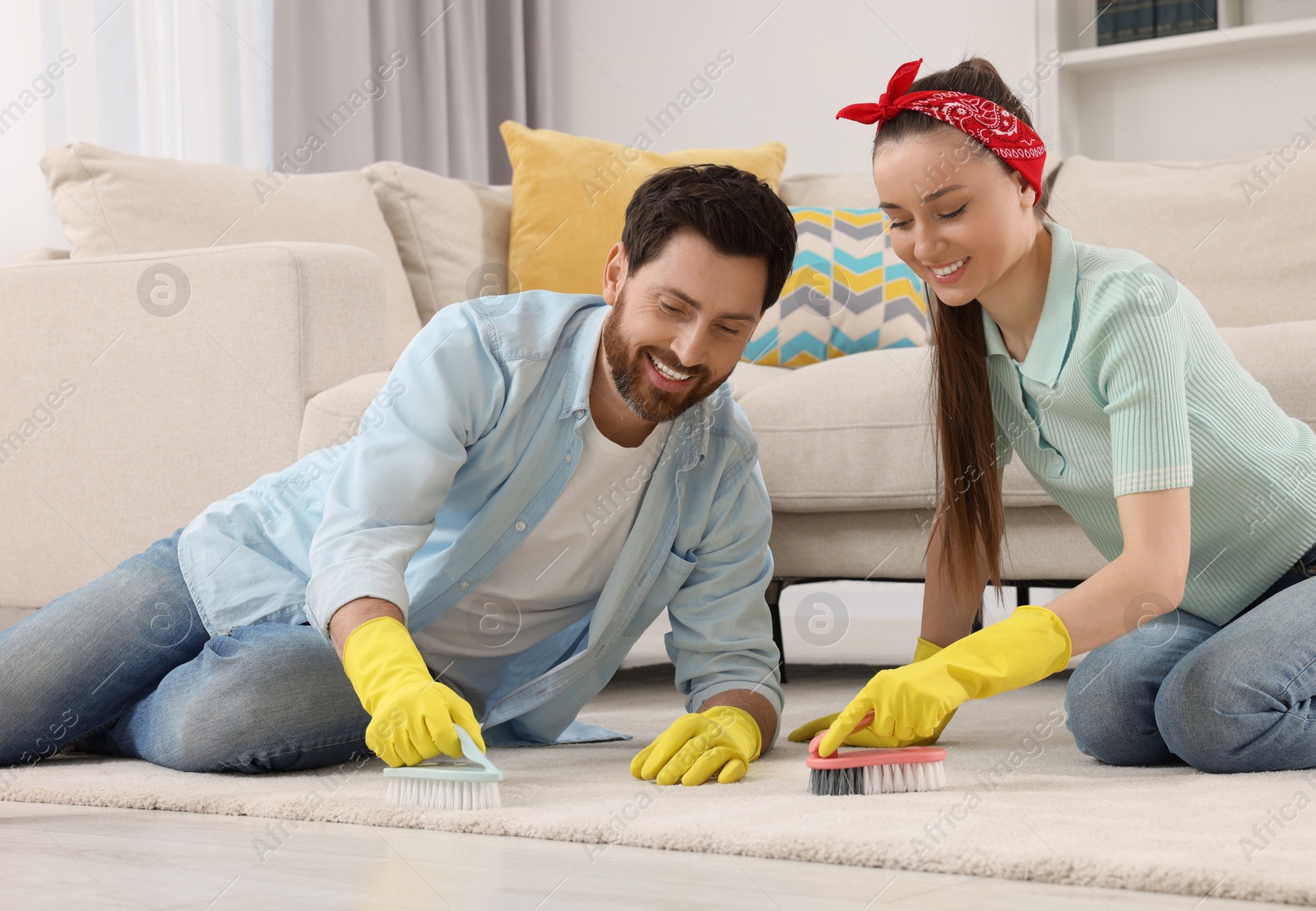 Photo of Spring cleaning. Couple tidying up living room together