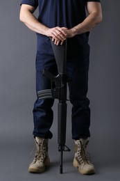 Photo of Assault gun. Man holding rifle on dark background, closeup