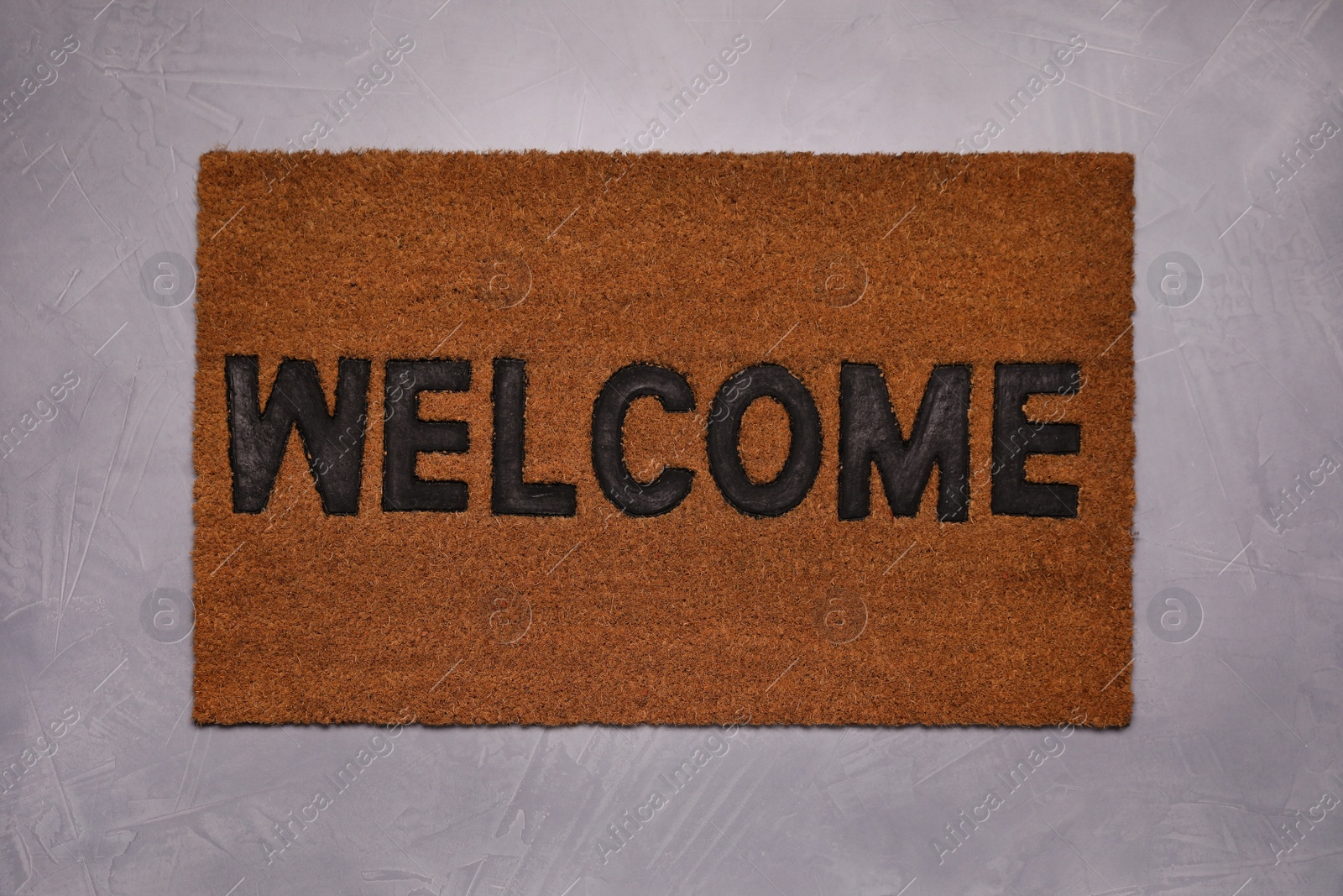 Photo of New clean mat with word WELCOME on floor, top view