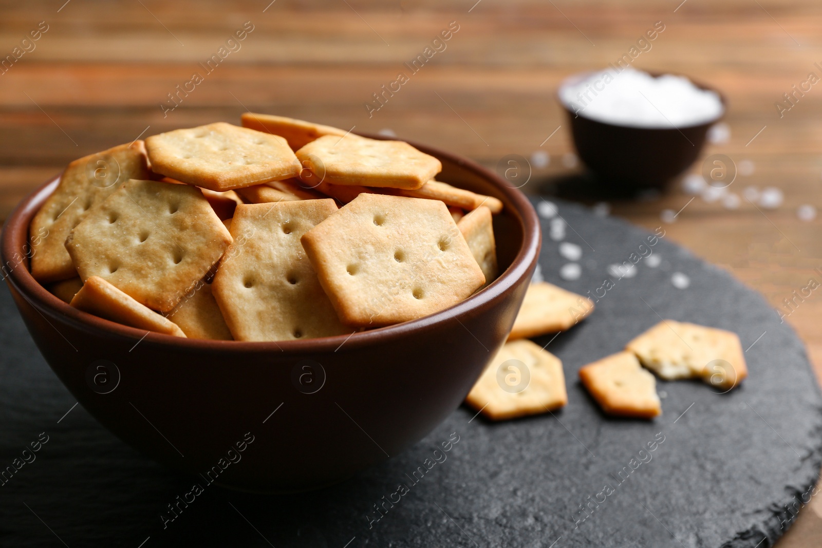 Photo of Delicious crispy crackers on wooden table, closeup