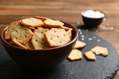 Delicious crispy crackers on wooden table, closeup