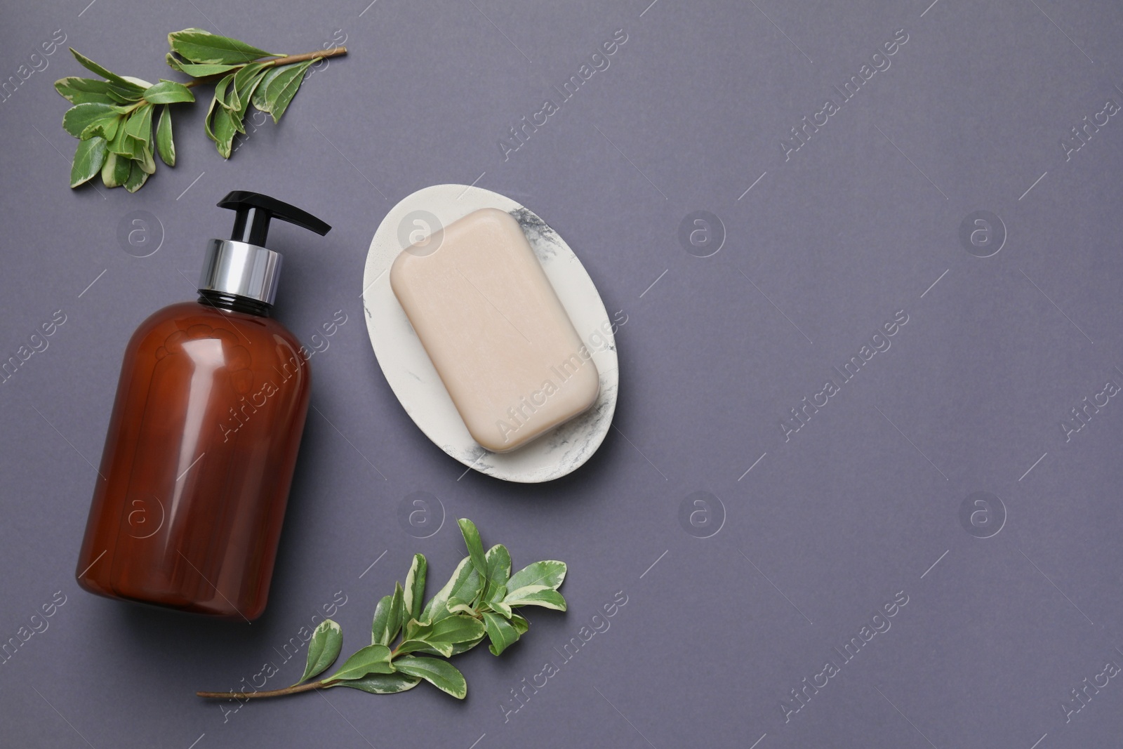 Photo of Soap bar, bottle dispenser and branches on black background, flat lay. Space for text
