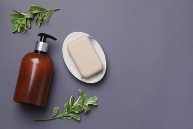 Photo of Soap bar, bottle dispenser and branches on black background, flat lay. Space for text