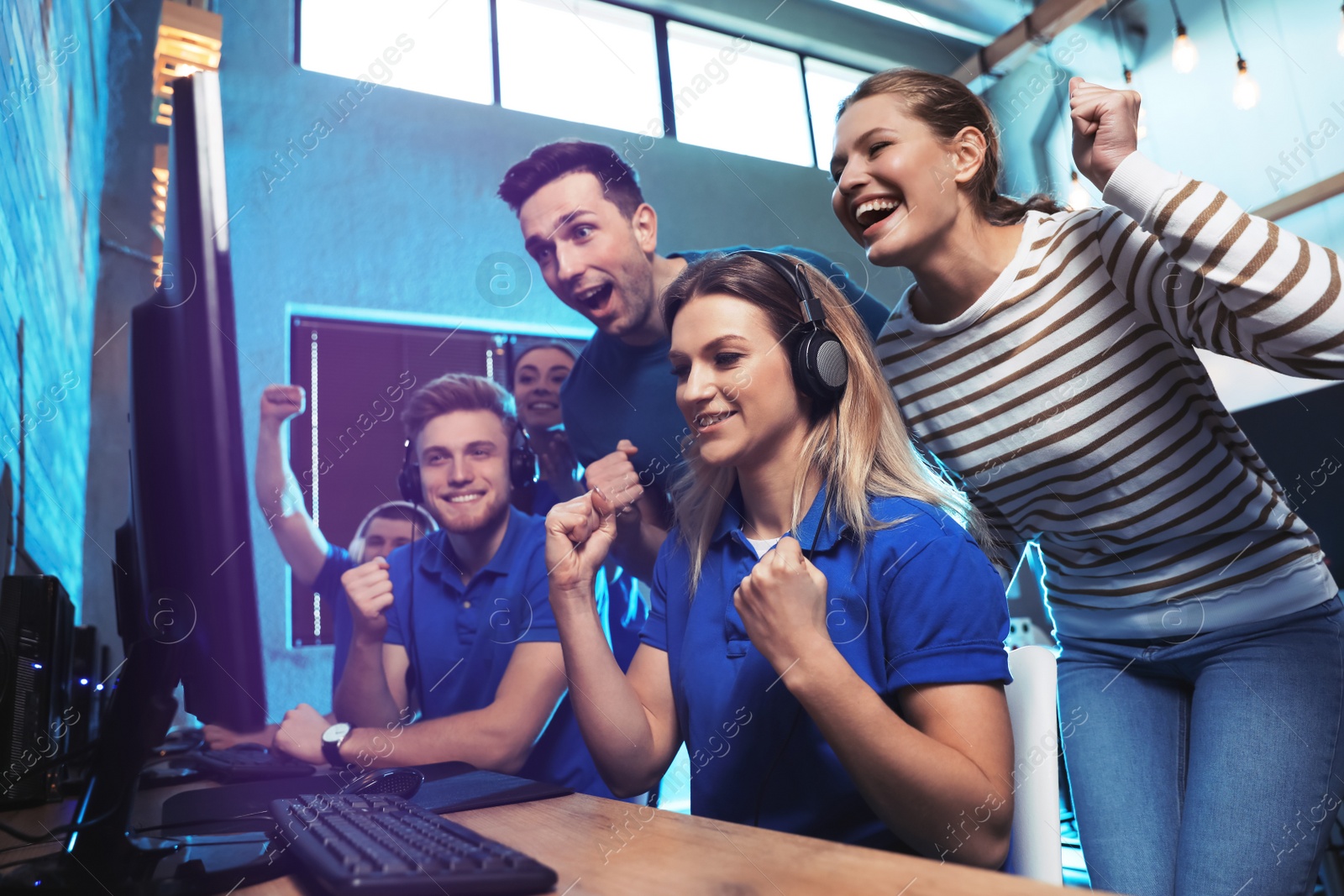 Photo of Group of people playing video games in internet cafe