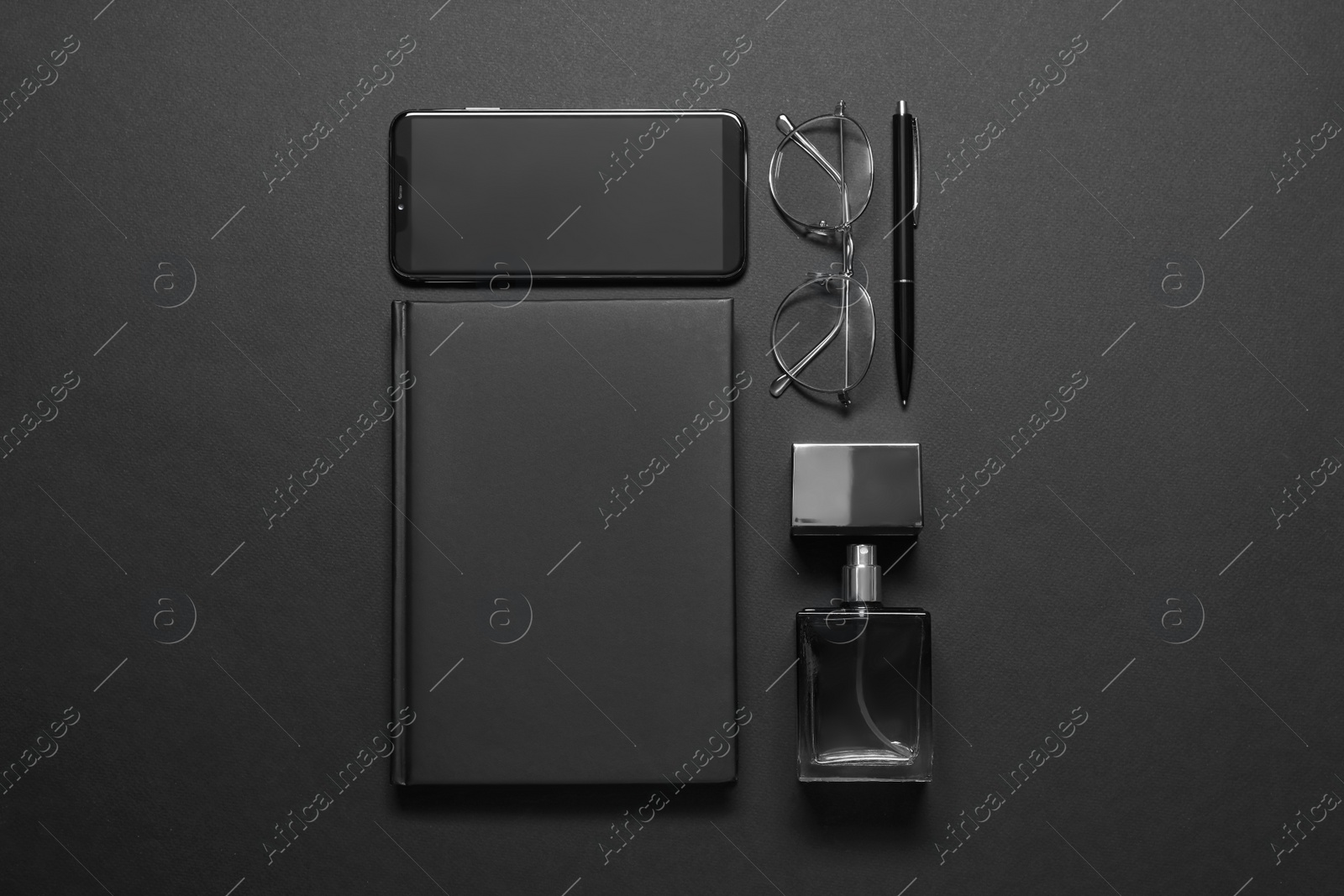 Photo of Flat lay composition with male accessories and smartphone on black background