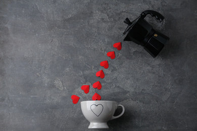 Flat lay composition with moka pot, cup and red paper hearts on grey background