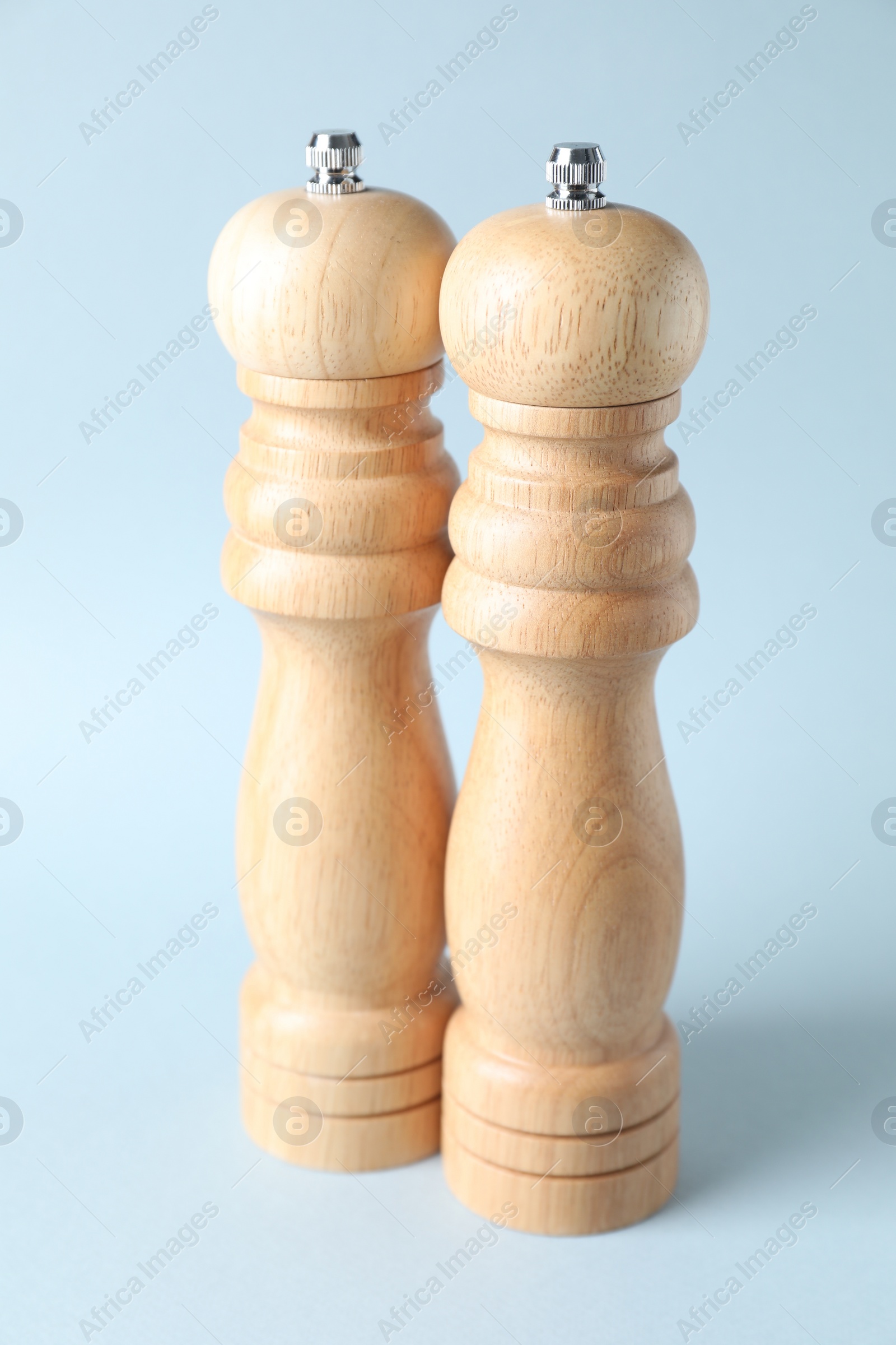 Photo of Wooden salt and pepper shakers on light background