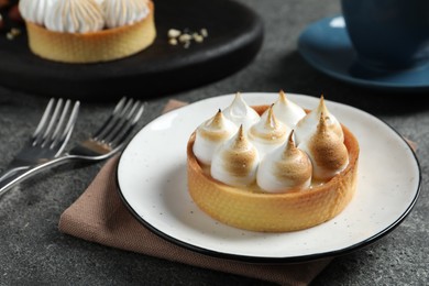 Tartlet with meringue served on dark grey table, closeup. Tasty dessert