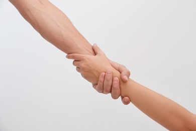 People holding hands together on light background. Concept of support and help