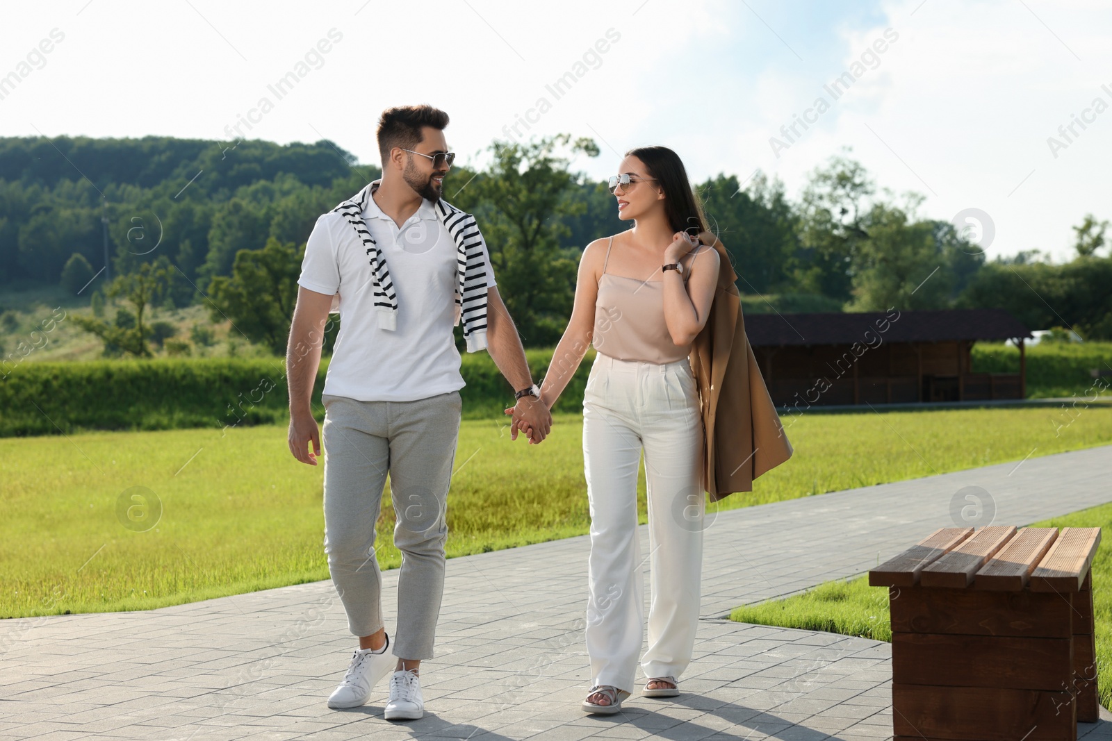 Photo of Romantic date. Beautiful couple walking in park on sunny day