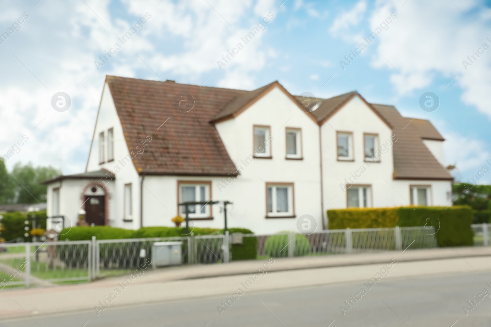 Photo of Blurred view of suburban street with beautiful house