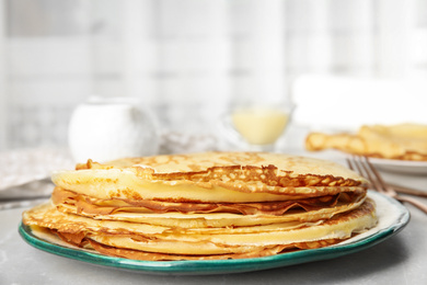 Stack of fresh thin pancakes on light grey marble table