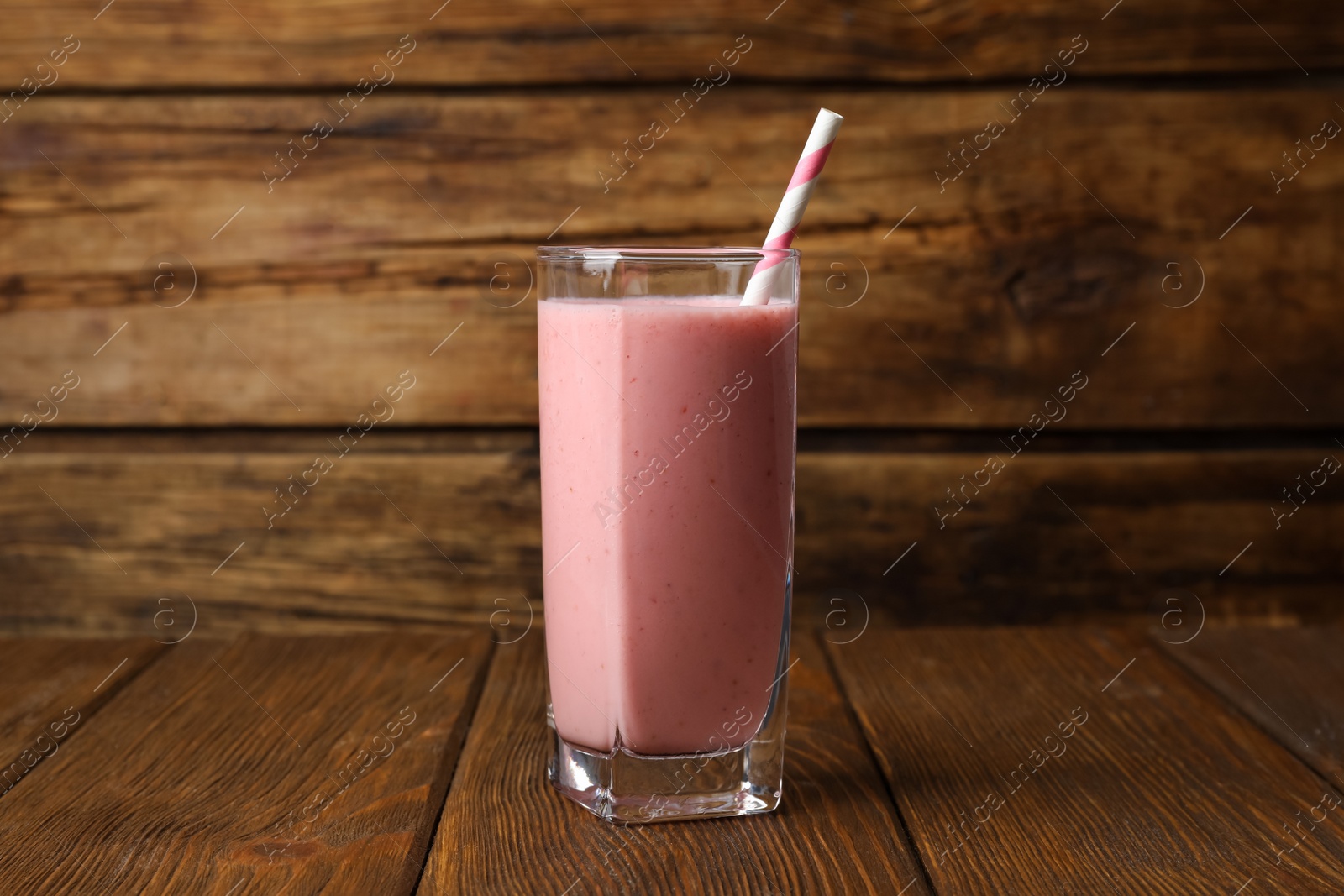 Photo of Glass with delicious berry smoothie on wooden table