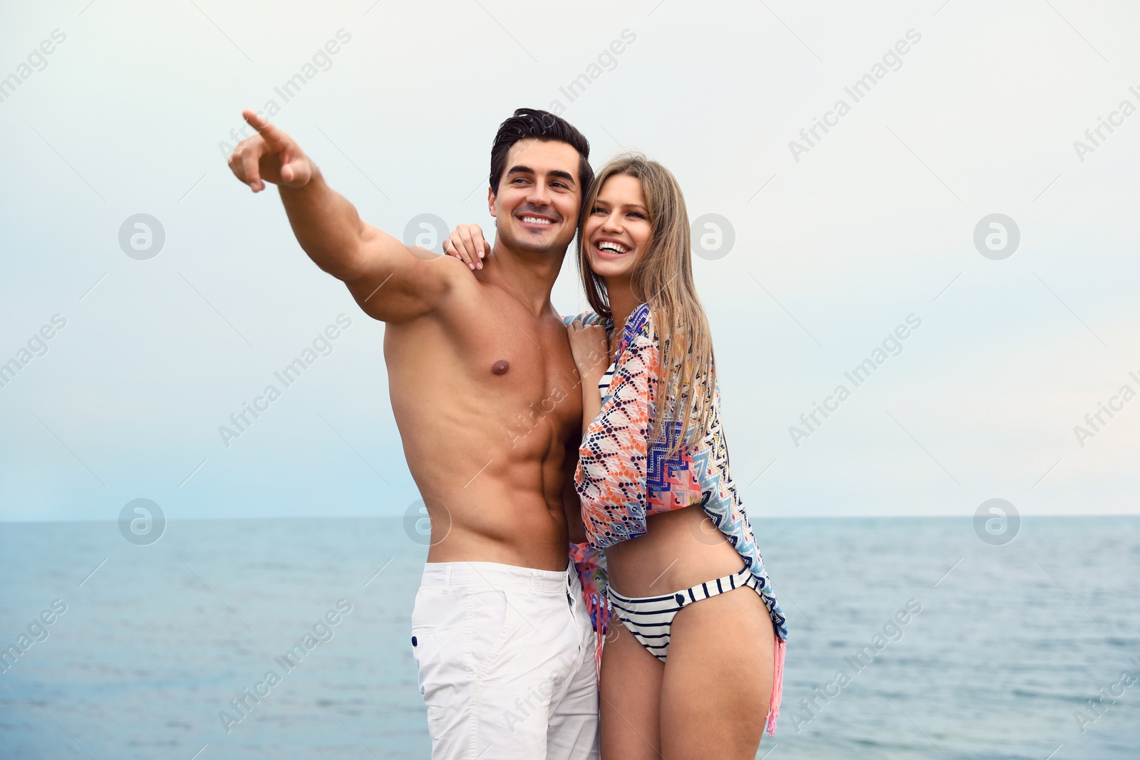 Photo of Happy young couple spending time together on sea beach