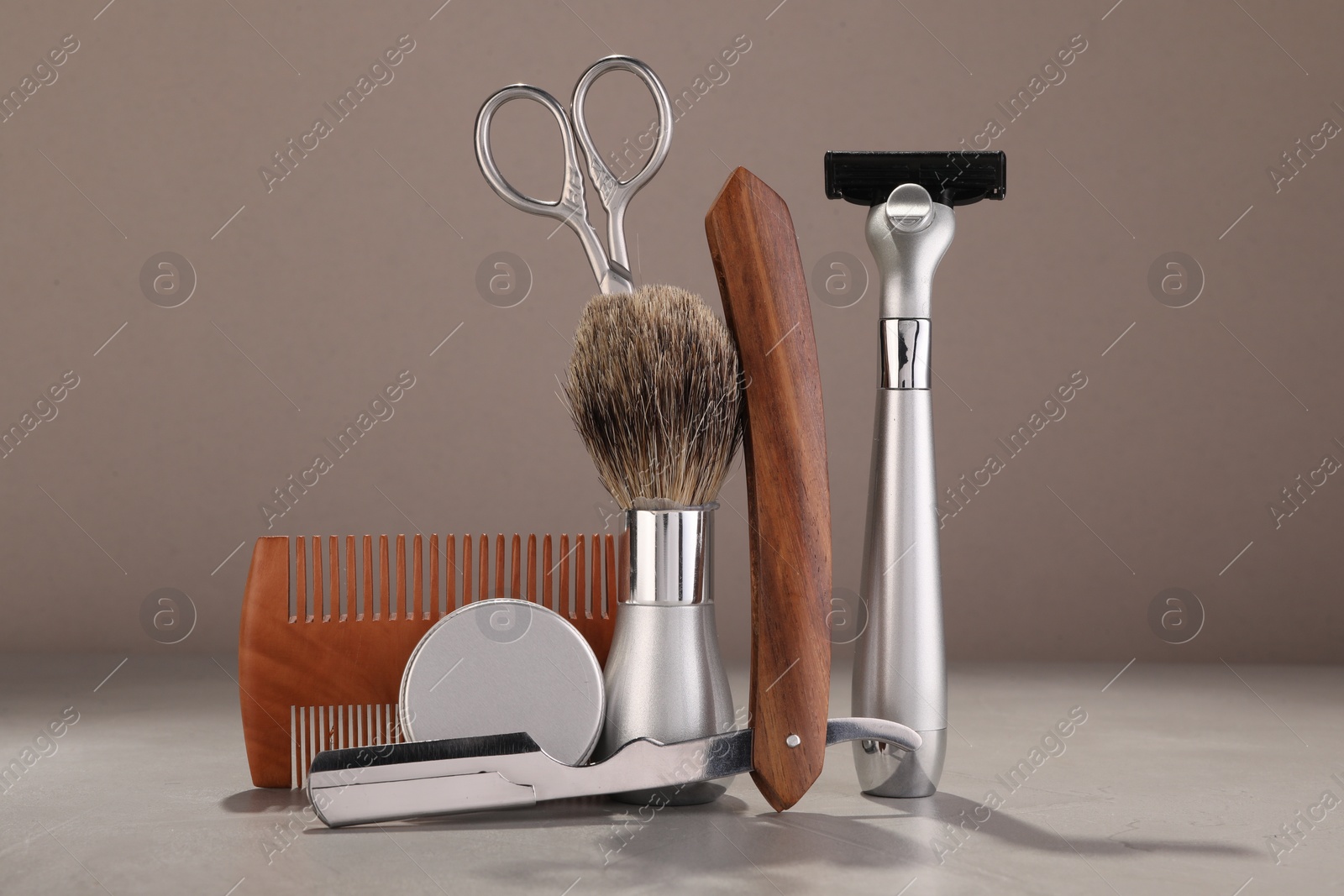 Photo of Moustache and beard styling tools on grey table