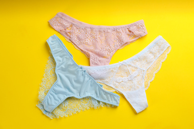 Photo of Women's underwear on yellow background, flat lay