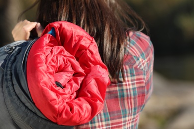 Female camper with sleeping bag outdoors, closeup