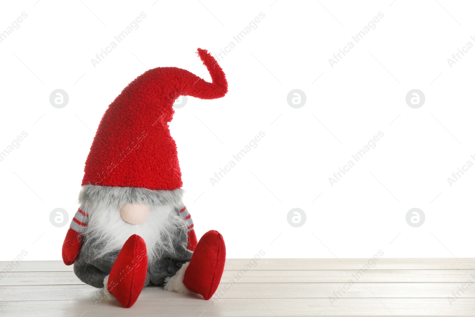 Photo of Funny Christmas gnome on wooden table against white background. Space for text