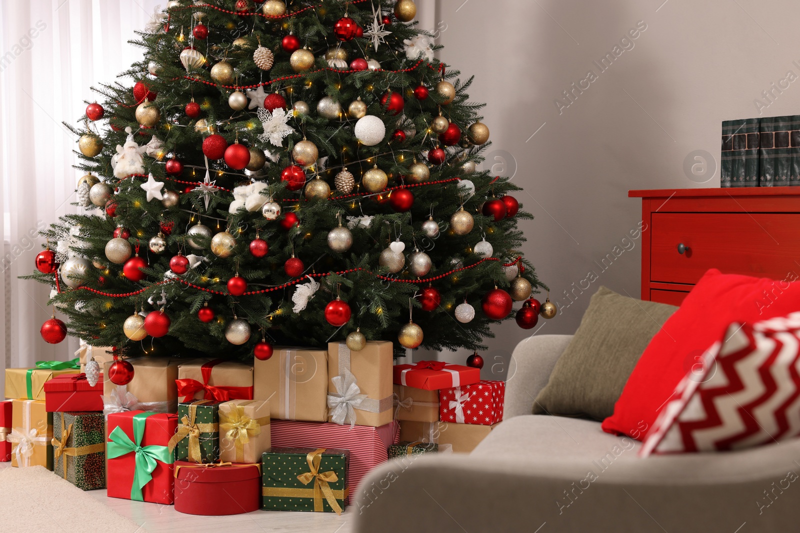 Photo of Beautiful Christmas tree and gifts in living room