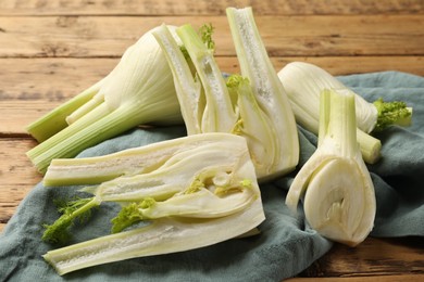 Photo of Whole and cut fennel bulbs on table, closeup