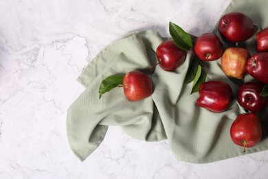 Photo of Fresh ripe red apples with leaves on white marble table, flat lay. Space for text