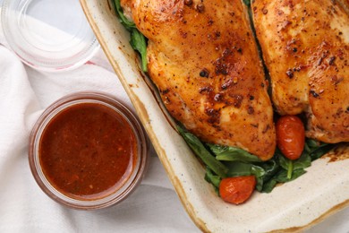 Baked chicken fillets with vegetables and marinade on table, flat lay