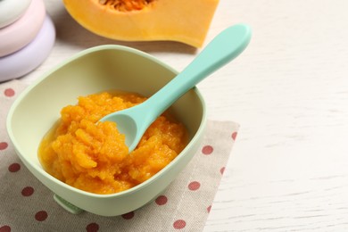 Baby food. Tasty pumpkin puree on white wooden table, closeup. Space for text