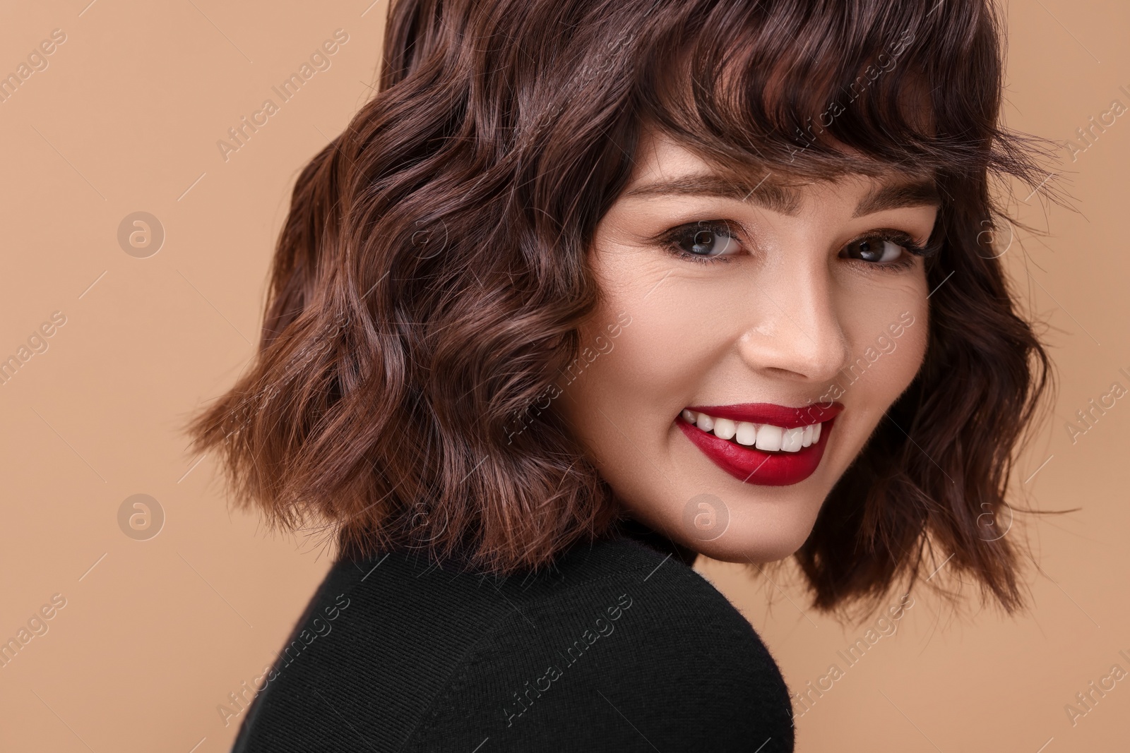 Photo of Beautiful young woman with wavy hairstyle on beige background