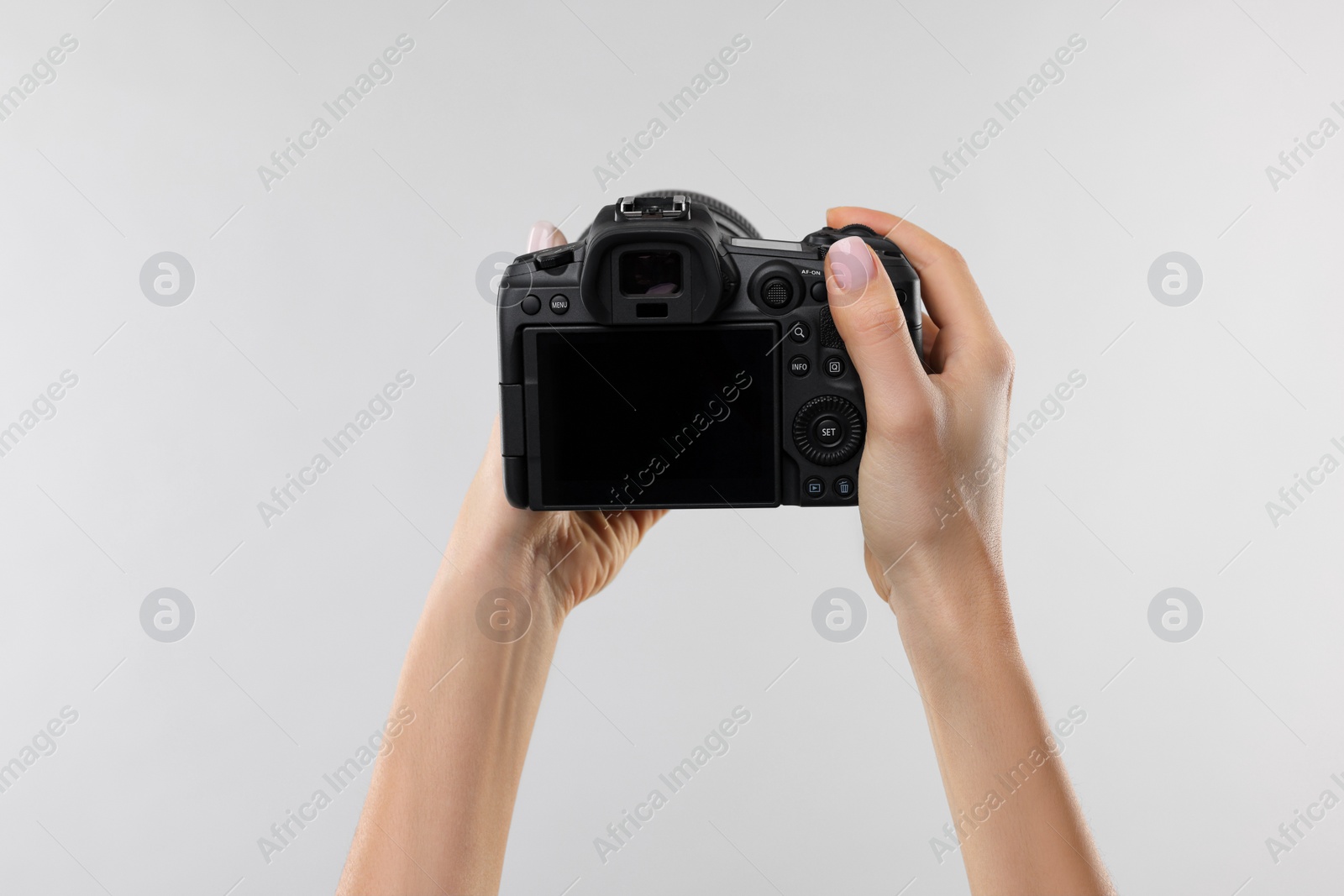 Photo of Photographer with camera on light grey background, closeup