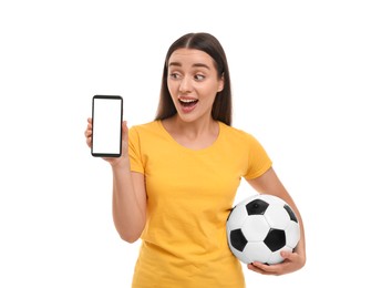 Photo of Surprised fan holding soccer ball and showing smartphone isolated on white