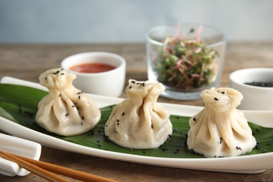 Plate with tasty baozi dumplings on table