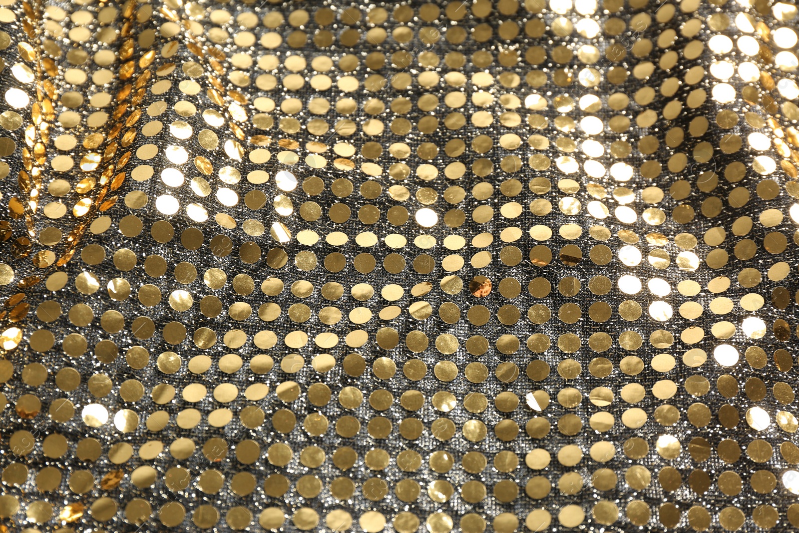 Photo of Closeup view of golden shiny sequin fabric as background